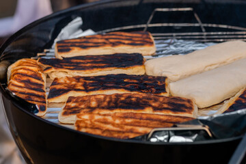 Process of cooking doner kebab on grill at summer local food market - close up. Outdoor cooking, barbecue, gastronomy, cookery and street food concept