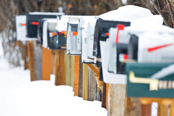 Winter snow covers a row of mailboxes.
