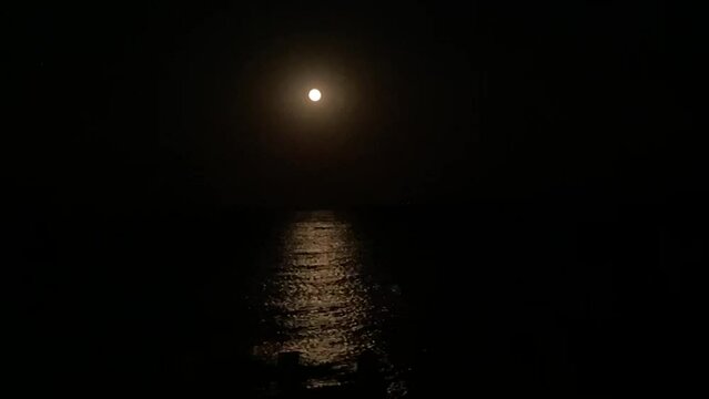 moon reflecting on ocean sea at night background with copy space