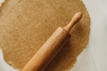 roll out the dough with a wooden rolling pin. wooden rolling pin and spread whole wheat dough top view