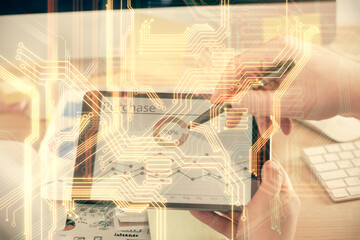 Fototapeta premium Double exposure of man's hands holding and using a digital device and tech theme hologram drawing. Technology concept.