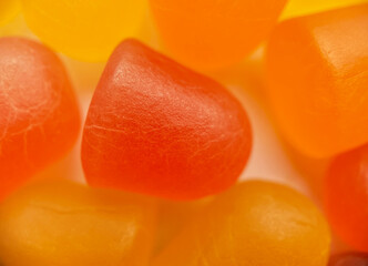 Close-up texture of orange and yellow multivitamin gummies on white background. Healthy lifestyle...