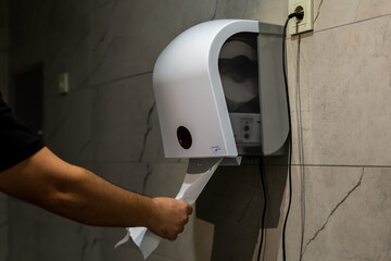 Paper towel machine. Man using paper towels