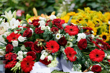 roses, gerbera, lilies and sunflowers on a grave after a funeral