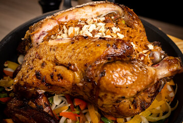 Whole roasted chicken  with vegetables stuffed with rice, on wooden table, delicious chicken