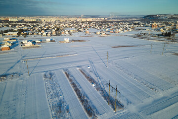 Aerial view of snow covered agricultural fields with barren surface in winter