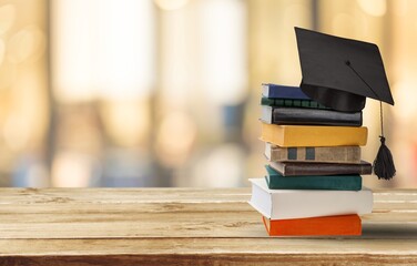 Graduation cap and set of books on a table
