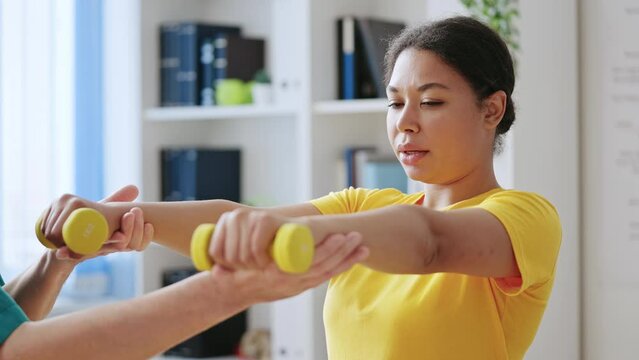 Woman With Muscular Dystrophy Feeling Pain While Doing Exercise With Dumbbells