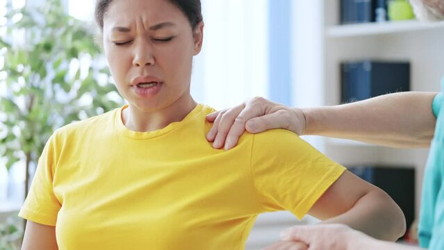 Female patient with shoulder pain visiting physiatrist, sports injury treatment