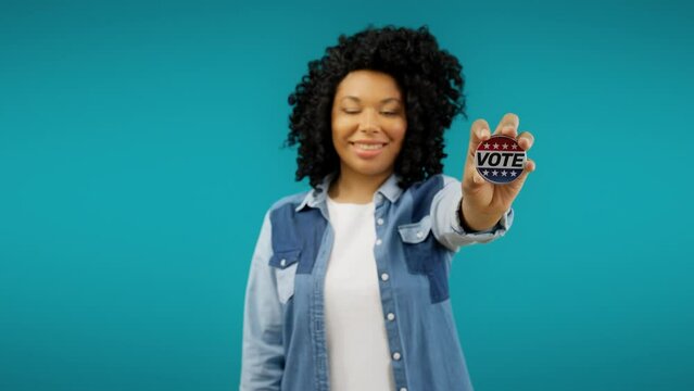 Attractive African American woman posing with vote pin, make your choice