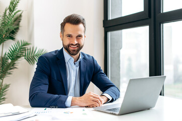 Portrait of a positive handsome confident successful caucasian man in a suit, IT specialist,...