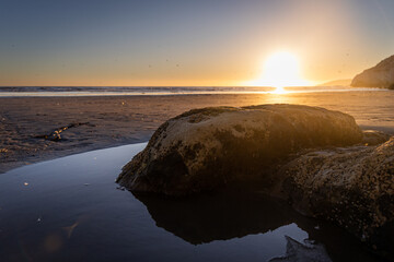 Rock reflection at beach sunset