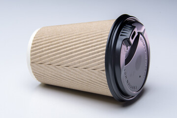 coffee paper cup with black cap, isolated on a with background, horizontal, close up studio photo