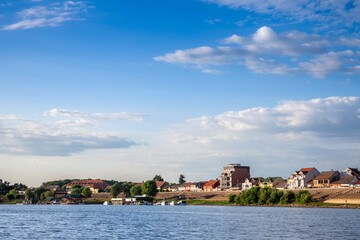 Panorama of the Reka Sava river with the watefront quay in the left and a few boats passing by in Sremska Mitrovica, a city of Vojvodina, in the srem region, in Serbia. ...