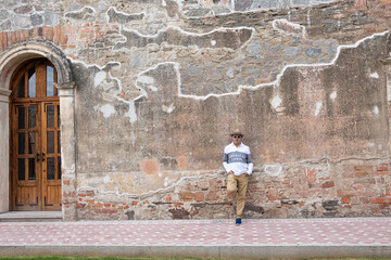Hombre con sombrero, posando en la entrada de una hacienda abandonada