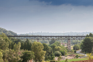 Fototapeta premium Panorama of Serbian nature with an iron steel metal railway bridge of serbian railways crossing a valley with a train infrastucture in summer, in Europe...