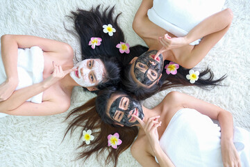 Three young women with facial masks holds finger near the closed mouth, keep secret and keep silence action  show to camera