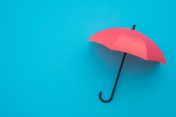 Red umbrella on blue background with copy space. Life insurance health protection concept. Finding the best life insurance for family.