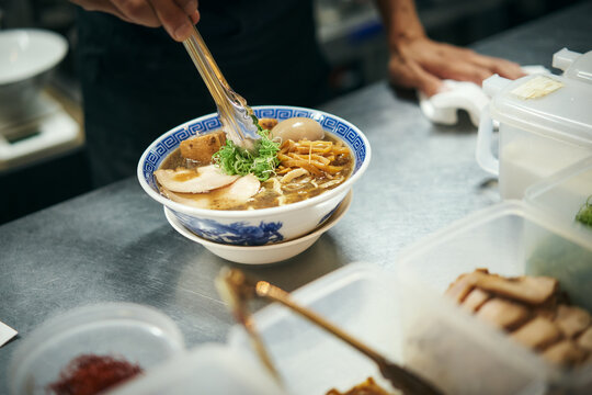 ラーメンの盛り付けをする職人の手元