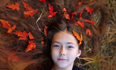 A beautiful girl walks in the autumn forest. A girl with long hair in an autumn park.