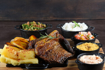 barbecued meat with cassava fried banana rice beans and herb sauce, typical brazilian food