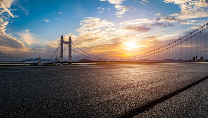 Empty asphalt road and bridge building with beautiful sky clouds at sunset - obrazy, fototapety, plakaty