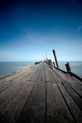 Naklejka na ściany i meble Wooden pier or jetty and sea at blue sky.
