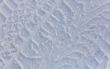 Traces from the car in the snow as a background.