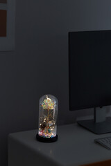 Close-up shot of a luminous romantic mother-of-pearl rose surrounded by sparkling LED lights in a...