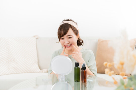 口角を上げる練習をする日本人女性（スキンケア）
