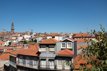Fototapeta na wymiar Tall buildings with colourful tiled facade walls in a Oporto skyline, in Portugal on a blue sunny sky