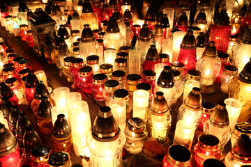 Znicze na grobie osoby bliskiej świeci podczas święta zmarłych wieczorem. Wrocławski cmentarz.  - obrazy, fototapety, plakaty