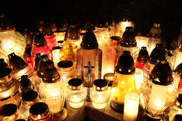 Znicze na grobie osoby bliskiej świeci podczas święta zmarłych wieczorem. Wrocławski cmentarz. 