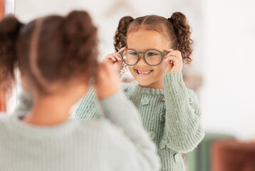 Children, mirror and girl with glasses at optometry store, testing or shopping for new eyewear. Vision, choice and happy kid trying spectacles or lenses at optics shop while looking at reflection. - obrazy, fototapety, plakaty