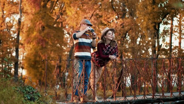 Tourist couple taking photo with a DSLR camera in the autumn park