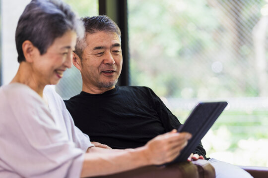 タブレットPCを見る日本人シニア夫婦