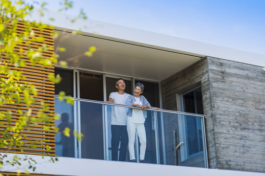 ベランダから外を眺める日本人シニア夫婦