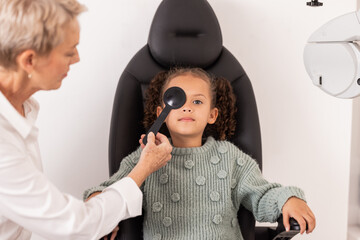 Eye exam, child and optometrist testing eye sight for glasses, blindness and new lense. Vision...