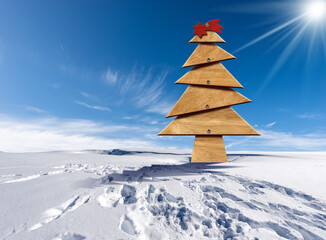 Wooden Christmas tree with red comet star on a snowy landscape against a clear blue sky with...