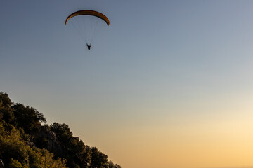 Paragliding flying alone in the sky at sunset