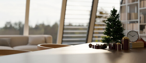 Empty space on modern wood dining table with Christmas tree, gift boxes and decor