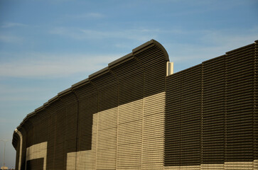 soundproof wall made of concrete porous ribbed material. fence of brown blocks inserted into metal...
