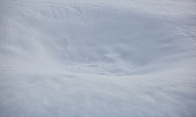 Hole in the snow surface. Blurred image, selective focus