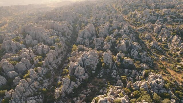 Aerial drone forward moving shot over beautiful rock formation in El Torcal de Antequera Nature reserve, Spain during evening time.