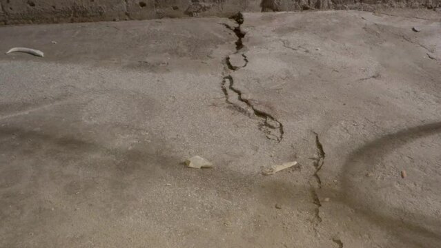 Cracks in the floor of concrete. The before shots of a garage floor before the ground restoration and epoxy flooring.