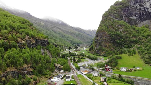 Aerial: flying over the Fl&aring;m valley among mountains, rivers and green meadows