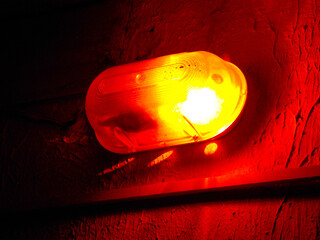 A lantern with a red signal on the wall. Close-up