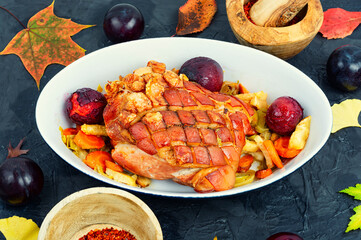 Pork shoulder baked with vegetables and plums.