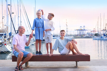 mom, dad, daughter and son happy family on sea marina background