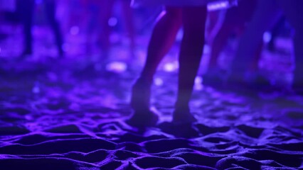 Closeup view of woman legs dancing at open air concert held on the beach at summer night. Lady is having fun and enjoying at the disco moving in the darkness. Atmosphere of excitement at music concert